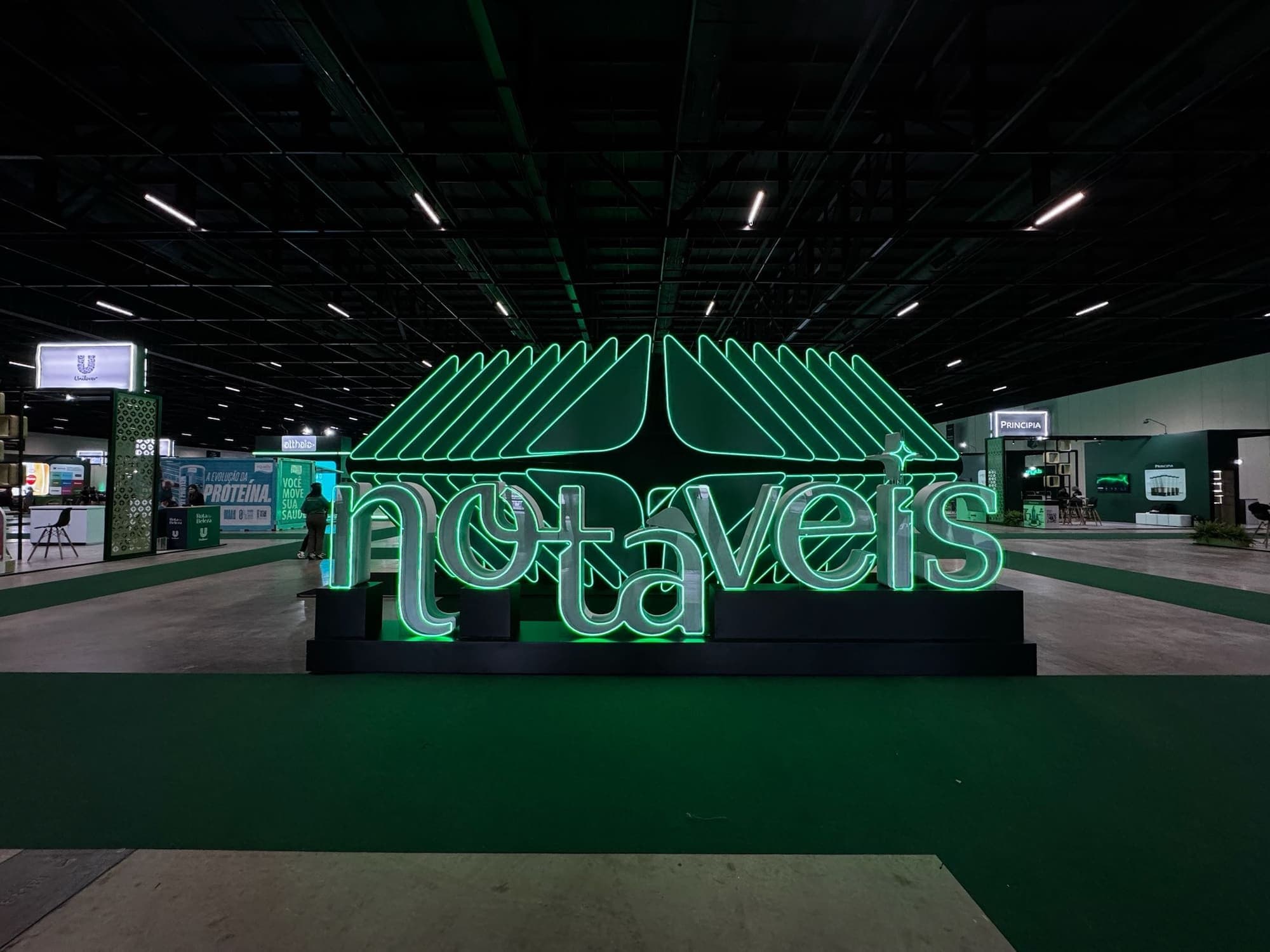Letreiro tridimensional iluminado com o nome do evento na entrada do pavilhão