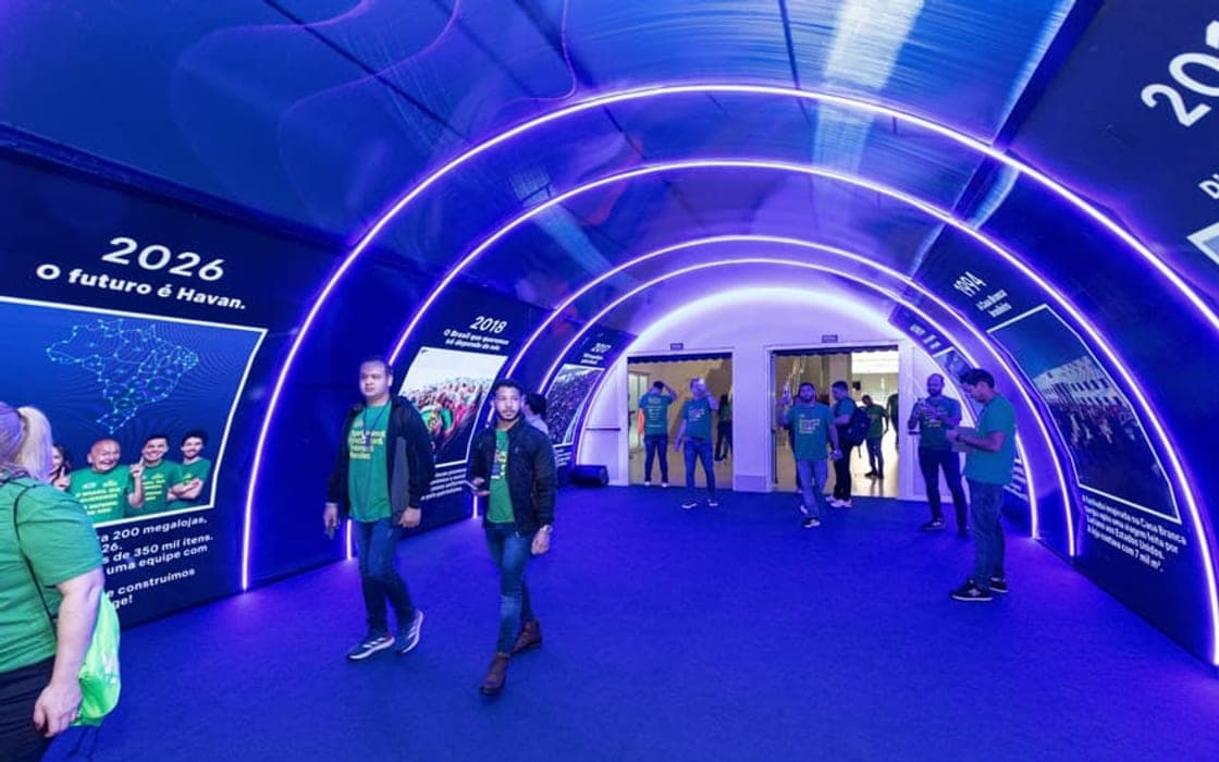 Público atravessando um túnel de entrada revestido de LED em evento corporativo
