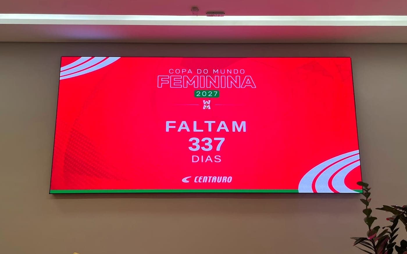 Tela em parede de escritório exibindo um número acompanhado em tempo real, com a marca do cliente