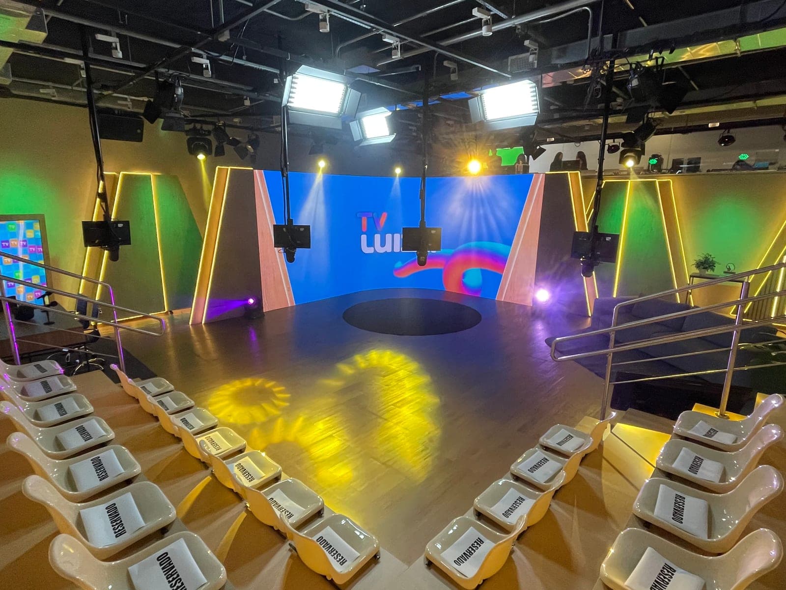 Estúdio TV Luiza, dentro do Magalu, com painel de LED curvo, grid de luz e arquibancada para plateia